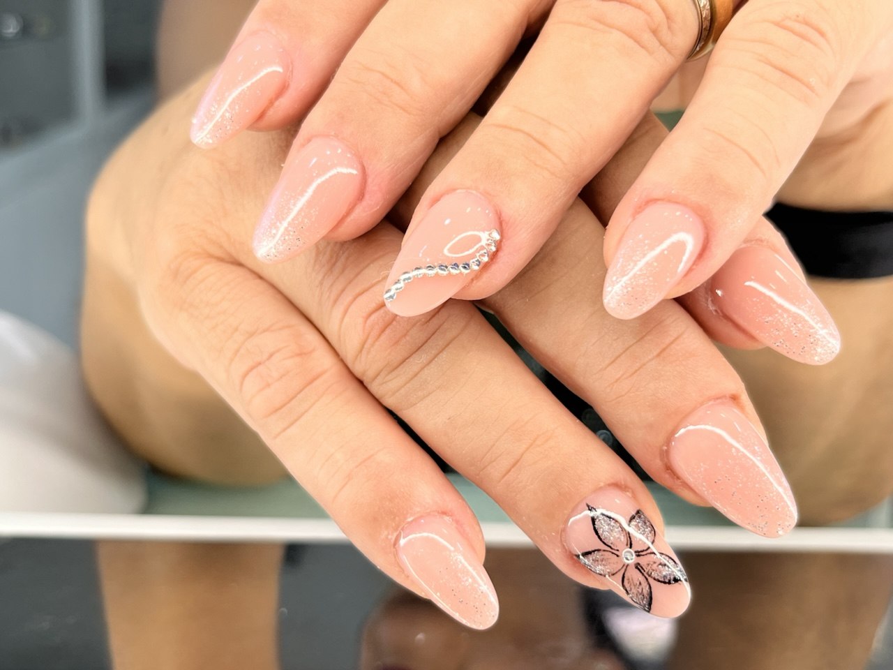 Unghie nude rosate con fiore dipinto a mano e strass