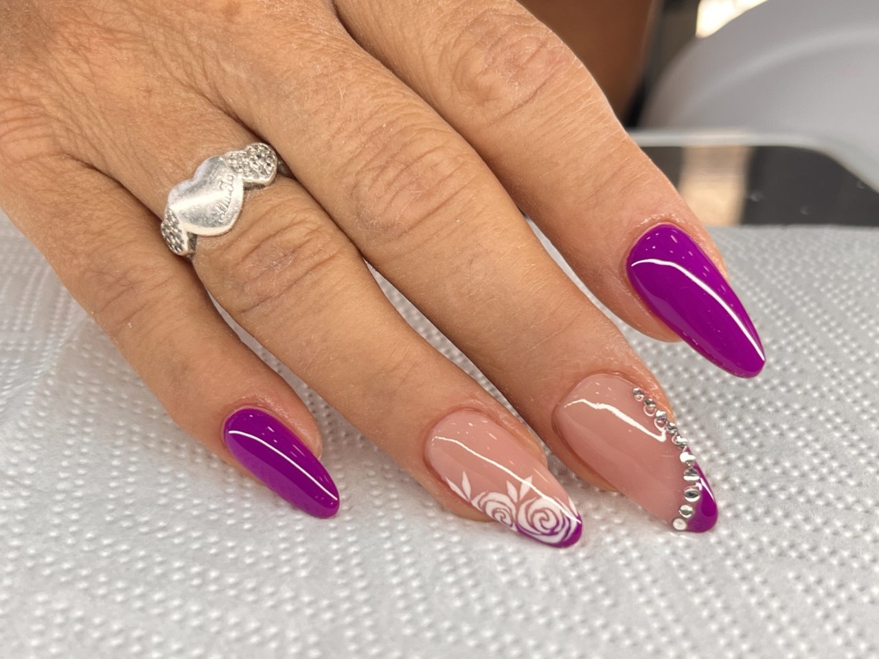 Nail art viola con rose bianche dipinte a mano e strass